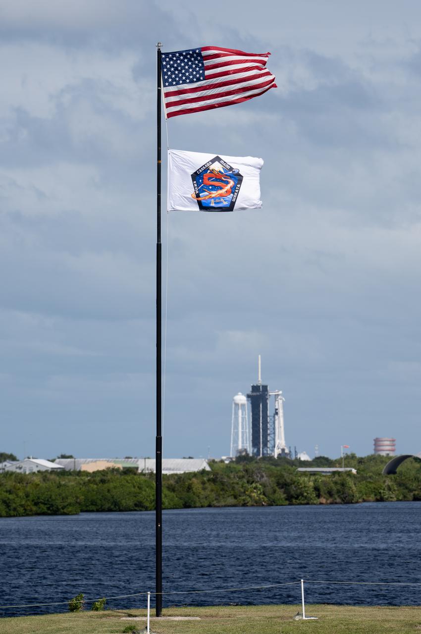The American flag and a flag bearing the patch for NASA’s SpaceX Crew-5 mission are seen at the Press Site and NASA’s Kennedy Space Center, Tuesday, Oct. 4, 2022, in Florida. NASA’s SpaceX Crew-5 mission is the fifth crew rotation mission of the SpaceX Crew Dragon spacecraft and Falcon 9 rocket to the International Space Station as part of the agency’s Commercial Crew Program. NASA astronauts Nicole Mann and Josh Cassada, Japan Aerospace Exploration Agency (JAXA) astronaut Koichi Wakata, and Roscosmos cosmonaut Anna Kikina are scheduled to launch at 12:00 p.m. EDT on Oct. 5 from Launch Complex 39A at the Kennedy Space Center. Photo Credit: (NASA/Joel Kowsky)