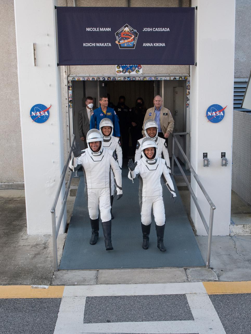 NASA astronauts Josh Cassada, front left, and Nicole Mann, front right, Roscosmos cosmonaut Anna Kikina, back left, and Japan Aerospace Exploration Agency (JAXA) astronaut Koichi Wakata, back right, wearing SpaceX spacesuits, are seen as they prepare to depart the Neil  A. Armstrong Operations and Checkout Building for Launch Complex 39A to board the SpaceX Crew Dragon spacecraft for the Crew-5 mission launch, Wednesday, Oct. 5, 2022, at NASA’s Kennedy Space Center in Florida. NASA’s SpaceX Crew-5 mission is the fifth crew rotation mission of the SpaceX Crew Dragon spacecraft and Falcon 9 rocket to the International Space Station as part of the agency’s Commercial Crew Program. Mann, Cassada, Wakata, and Kikini are scheduled to launch at 12:00 p.m. EDT, from Launch Complex 39A at the Kennedy Space Center.  Photo Credit: (NASA/Joel Kowsky)