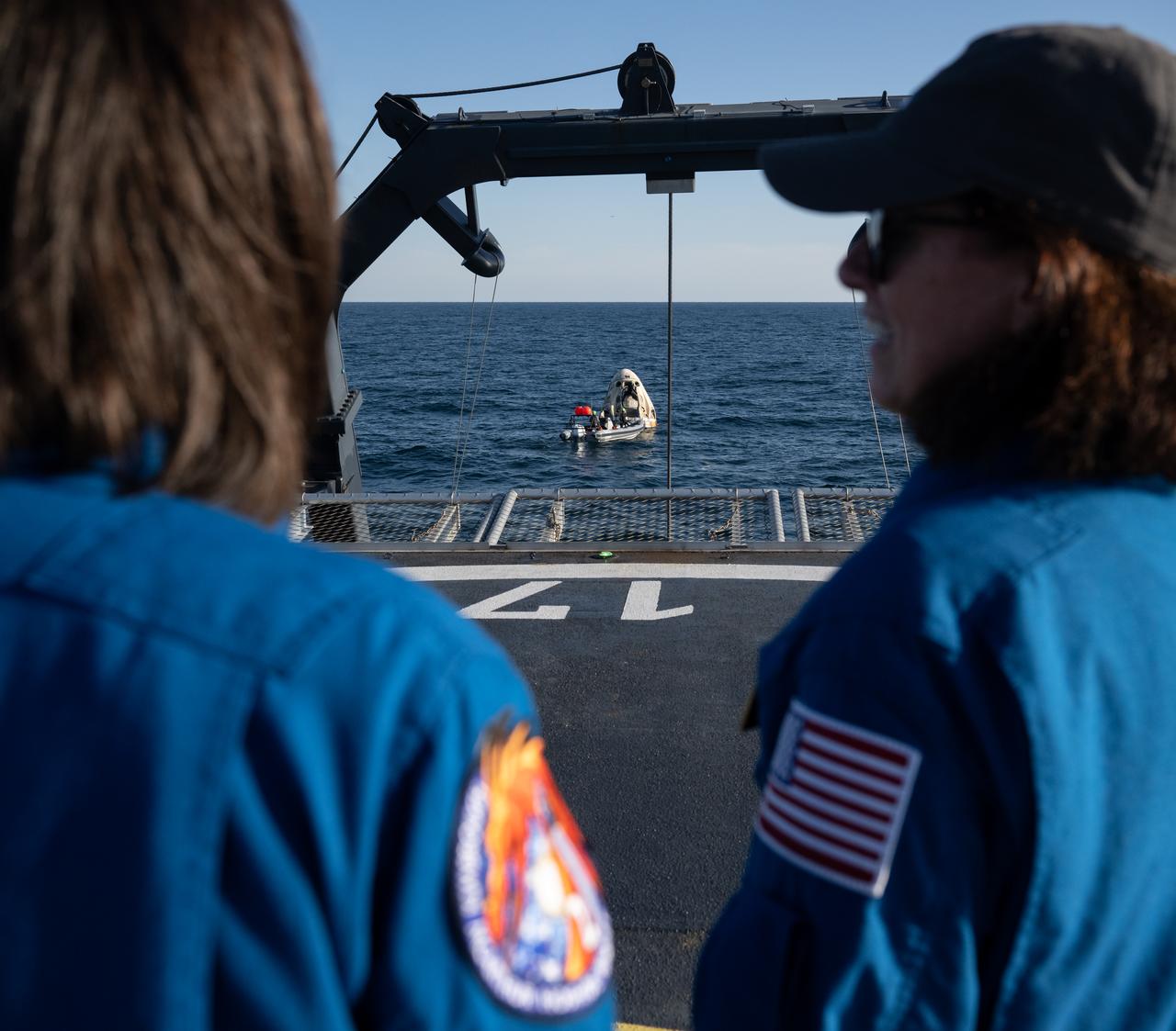 NASA astronaut representative Megan Behnken, left, and NASA astronaut and Crew Recovery Chief Shannon Walker watch as support teams work around the SpaceX Crew Dragon Freedom spacecraft shortly after it landed with NASA astronauts Kjell Lindgren, Robert Hines, Jessica Watkins, and ESA (European Space Agency) astronaut Samantha Cristoforetti aboard in the Atlantic Ocean off the coast of Jacksonville, Florida, Friday, Oct. 14, 2022. Lindgren, Hines, Watkins, and Cristoforetti are returning after 170 days in space as part of Expeditions 67 and 68 aboard the International Space Station. Photo Credit: (NASA/Bill Ingalls)