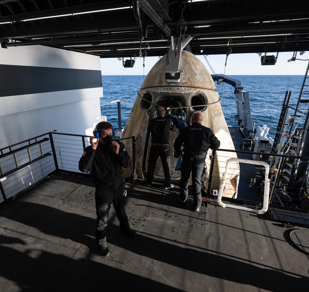 Support teams onboard the recovery ship Megan work around the SpaceX Crew Dragon Freedom spacecraft shortly after it landed with NASA astronauts Kjell Lindgren, Robert Hines, Jessica Watkins, and ESA (European Space Agency) astronaut Samantha Cristoforetti aboard in the Atlantic Ocean off the coast of Jacksonville, Florida, Friday, Oct. 14, 2022. Lindgren, Hines, Watkins, and Cristoforetti are returning after 170 days in space as part of Expeditions 67 and 68 aboard the International Space Station. Photo Credit: (NASA/Bill Ingalls)