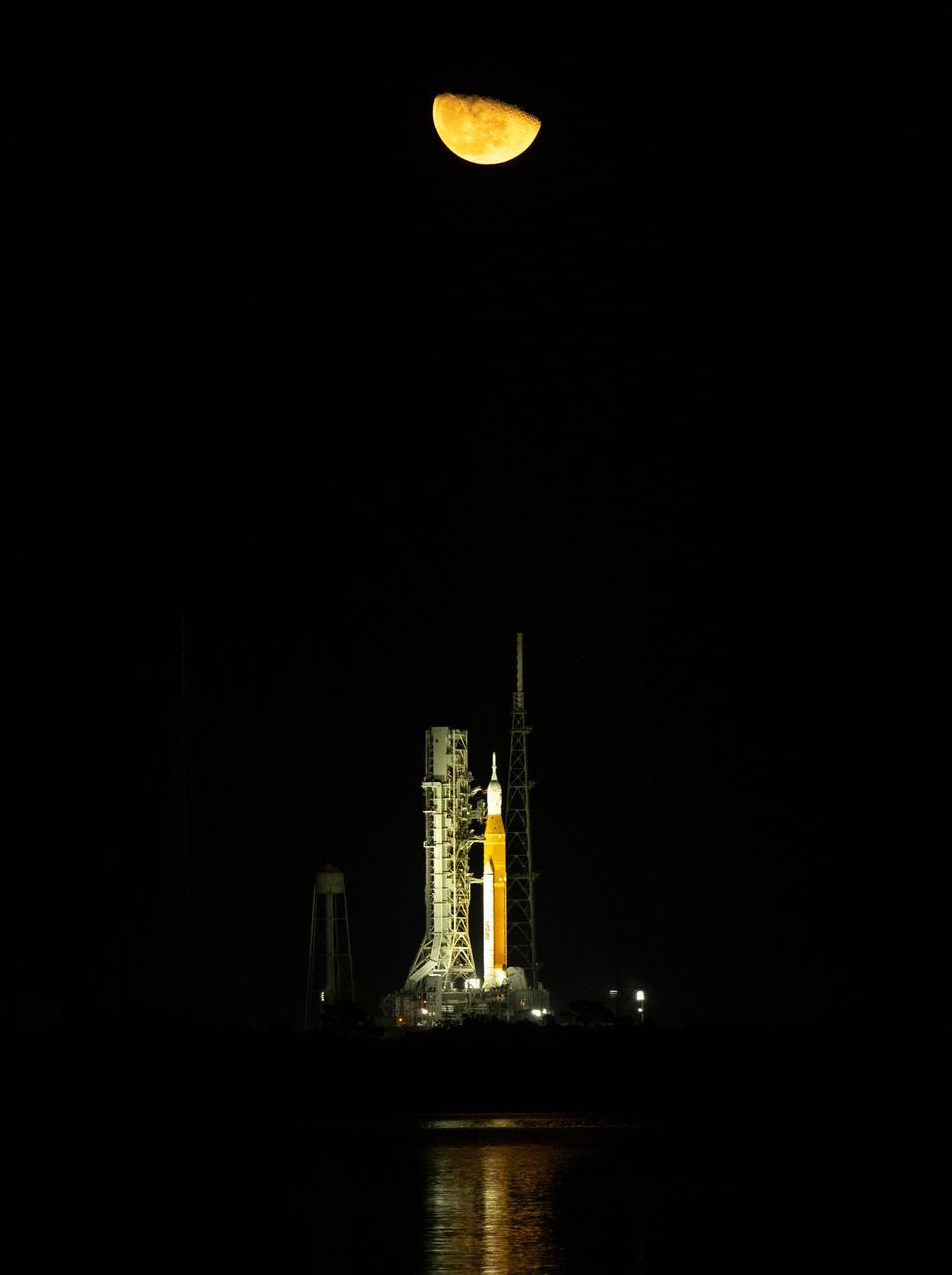 The Moon is seen rising above NASA’s Space Launch System (SLS) rocket with the Orion spacecraft aboard at Launch Pad 39B as preparations for launch continue, Monday, Nov. 14, 2022, at NASA’s Kennedy Space Center in Florida. NASA’s Artemis I flight test is the first integrated test of the agency’s deep space exploration systems: the Orion spacecraft, SLS rocket, and supporting ground systems. Launch of the uncrewed flight test is targeted for no earlier than Nov. 16 at 1:04 a.m. EST. Photo Credit: (NASA/Bill Ingalls)