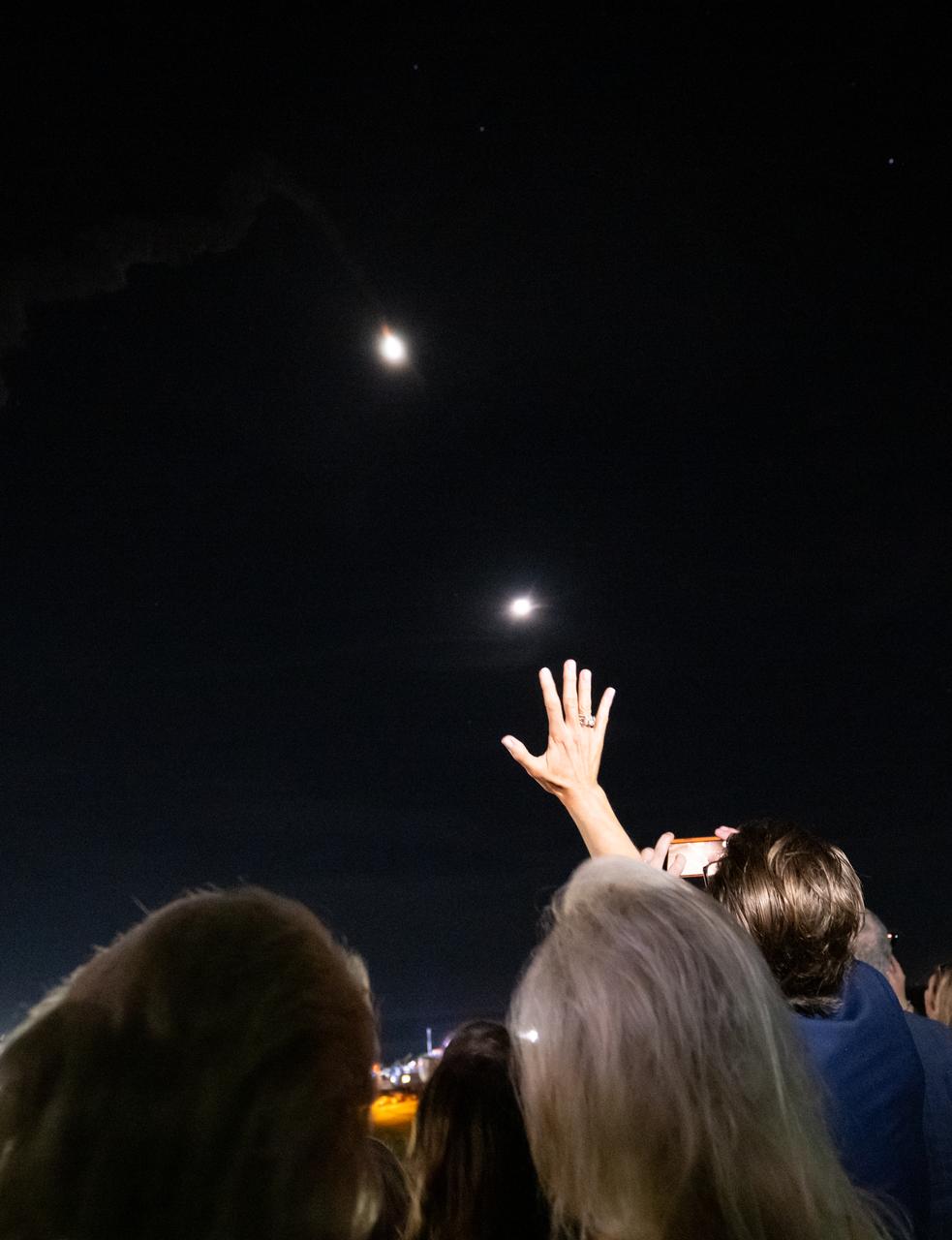 Guests watch the launch of NASA’s Space Launch System rocket carrying the Orion spacecraft on the Artemis I flight test, Wednesday, Nov. 16, 2022, from Operations and Support Building II at NASA’s Kennedy Space Center in Florida. NASA’s Artemis I flight test is the first integrated flight test of the agency’s deep space exploration systems: the Orion spacecraft, Space Launch System (SLS) rocket, and ground systems. SLS and Orion launched at 1:47 a.m. EST, from Launch Pad 39B at the Kennedy Space Center. The Moon is in the upper right. Photo Credit: (NASA/Bill Ingalls)