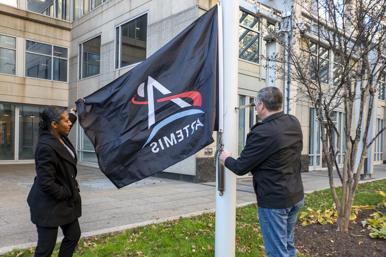 Artemis Mission Development Manager Mike Sarafin, Artemis Mission Integration Manager Sheela Logan, and Assistant Deputy Associate Administrator for Exploration Systems Development Tom Whitmeyer raise Artemis flags Wednesday, Nov. 23, 2022, at the Mary W. Jackson NASA Headquarters building in Washington. Photo Credit: (NASA/Keegan Barber)
