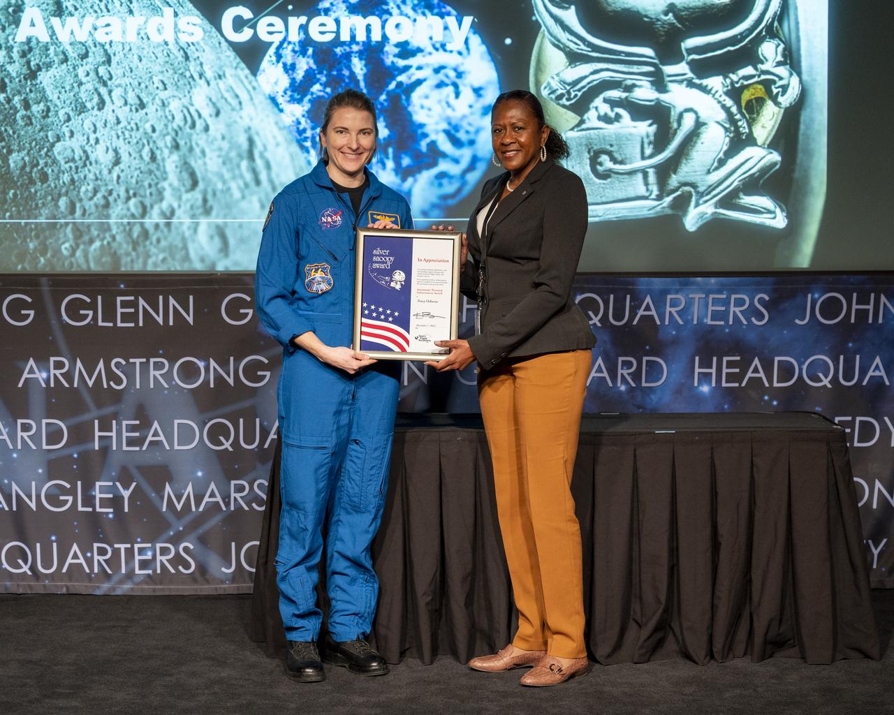 NASA astronaut Kayla Barron presents Tracy Osborne with the Space Flight Awareness (SFA) Silver Snoopy award Wednesday, Dec. 7, 2022, at the Mary W. Jackson NASA Headquarters building in Washington.  Photo Credit: (NASA/Keegan Barber)