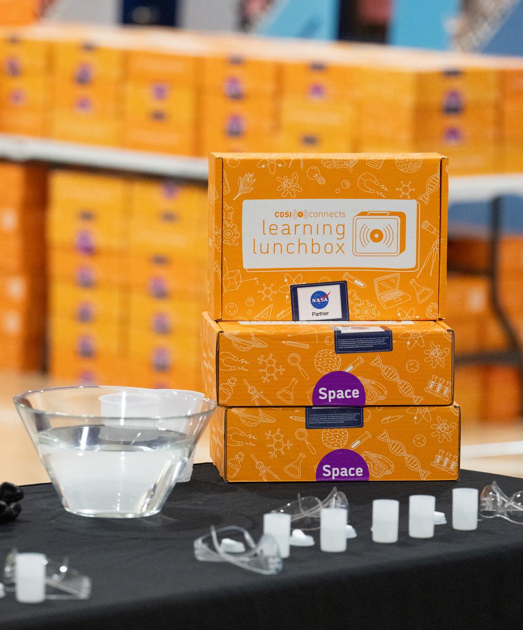 Center of Science and Industry (COSI) learning lunchboxes are seen during NASA Administrator Bill Nelson and NASA astronauts Raja Chari, Kayla Barron, Tom Marshburn, and Mark Vande Hei’s visit to Amidon-Bowen Elementary School, Thursday, Dec. 8, 2022, in Washington. Vande Hei spent 355 days in space as a member of Expedition 65/66 and was joined during Expedition 66 by Marshburn, Chari, and Barron who spent 177 days onboard the International Space Station. Photo Credit: (NASA/Keegan Barber)