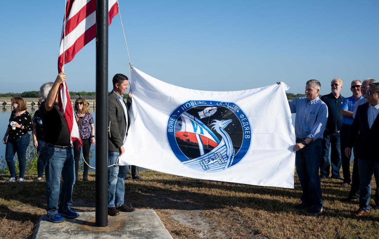 Trip Healey, manager, Program Control & Integration for NASA’s Commercial Crew Program, left, and Steve Stich, manager of NASA’s Commercial Crew Program right, prepare to raise the SpaceX Crew-6 flag, Wednesday, Feb. 22, 2023, at NASA’s Kennedy Space Center in Florida. NASA’s SpaceX Crew-6 mission is the sixth crew rotation mission of the SpaceX Dragon spacecraft and Falcon 9 rocket to the International Space Station as part of the agency’s Commercial Crew Program. NASA astronauts Stephen Bowen and Warren "Woody" Hoburg, UAE (United Arab Emirates) astronaut Sultan Alneyadi, and Roscosmos cosmonaut Andrey Fedyaev are scheduled to launch at 1:45 a.m. EST on Feb. 27 from Launch Complex 39A at the Kennedy Space Center. Photo Credit: (NASA/Joel Kowsky)