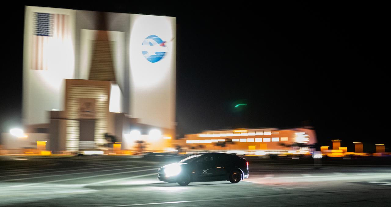 A vehicle carrying two members of NASA’s SpaceX Crew 6 mission passes by the Vehicle Assembly Building as it returns to the Neil A. Armstrong Operations and Checkout Building from Launch Complex 39A following the completion of a dress rehearsal for the Crew 6 launch, Friday, Feb. 24, 2023, at NASA’s Kennedy Space Center in Florida. NASA’s SpaceX Crew-6 mission is the sixth crew rotation mission of the SpaceX Dragon spacecraft and Falcon 9 rocket to the International Space Station as part of the agency’s Commercial Crew Program. Bowen, Hoburg, Alneyadi, and Fedyaev are scheduled to launch at 1:45 a.m. EST on Feb. 27, from Launch Complex 39A at the Kennedy Space Center. Photo Credit: (NASA/Joel Kowsky)