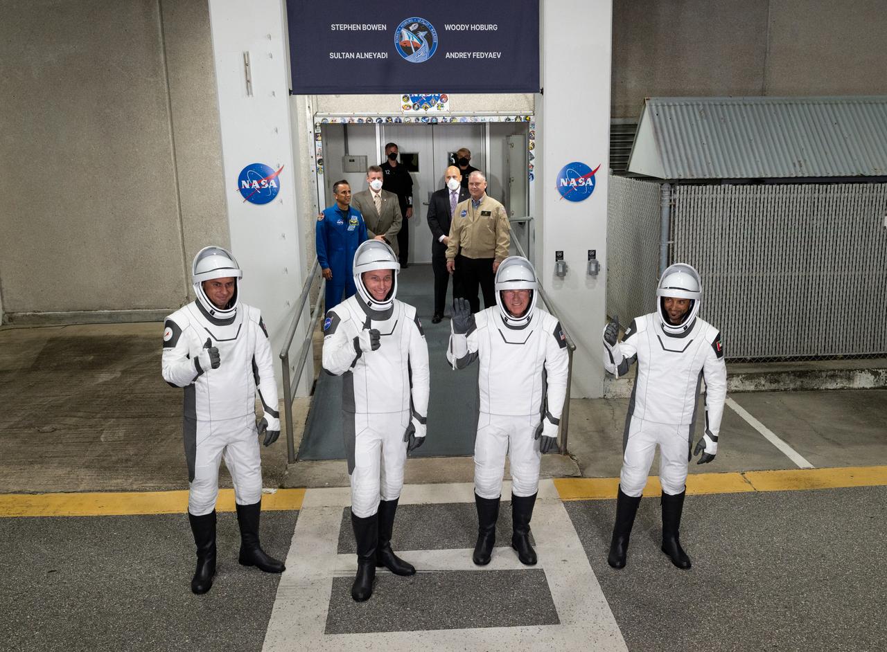Roscosmos cosmonaut Andrey Fedyaev, left,NASA astronaut Warren “Woody" Hoburg, second from left, NASA astronaut Stephen Bowen, second from right, and UAE (United Arab Emirates) astronaut Sultan Alneyadi, right, wearing SpaceX spacesuits, are seen as they prepare to depart the Neil A. Armstrong Operations and Checkout Building for Launch Complex 39A to board the SpaceX Dragon spacecraft for the Crew-6 mission launch, Wednesday, March 1, 2023, at NASA’s Kennedy Space Center in Florida. NASA’s SpaceX Crew-6 mission is the sixth crew rotation mission of the SpaceX Crew Dragon spacecraft and Falcon 9 rocket to the International Space Station as part of the agency’s Commercial Crew Program. Bowen, Hoburg, Alneyadi, and Fedyaev are scheduled to launch at 12:34 a.m. EST on March 2, from Launch Complex 39A at the Kennedy Space Center. Photo Credit: (NASA/Joel Kowsky)