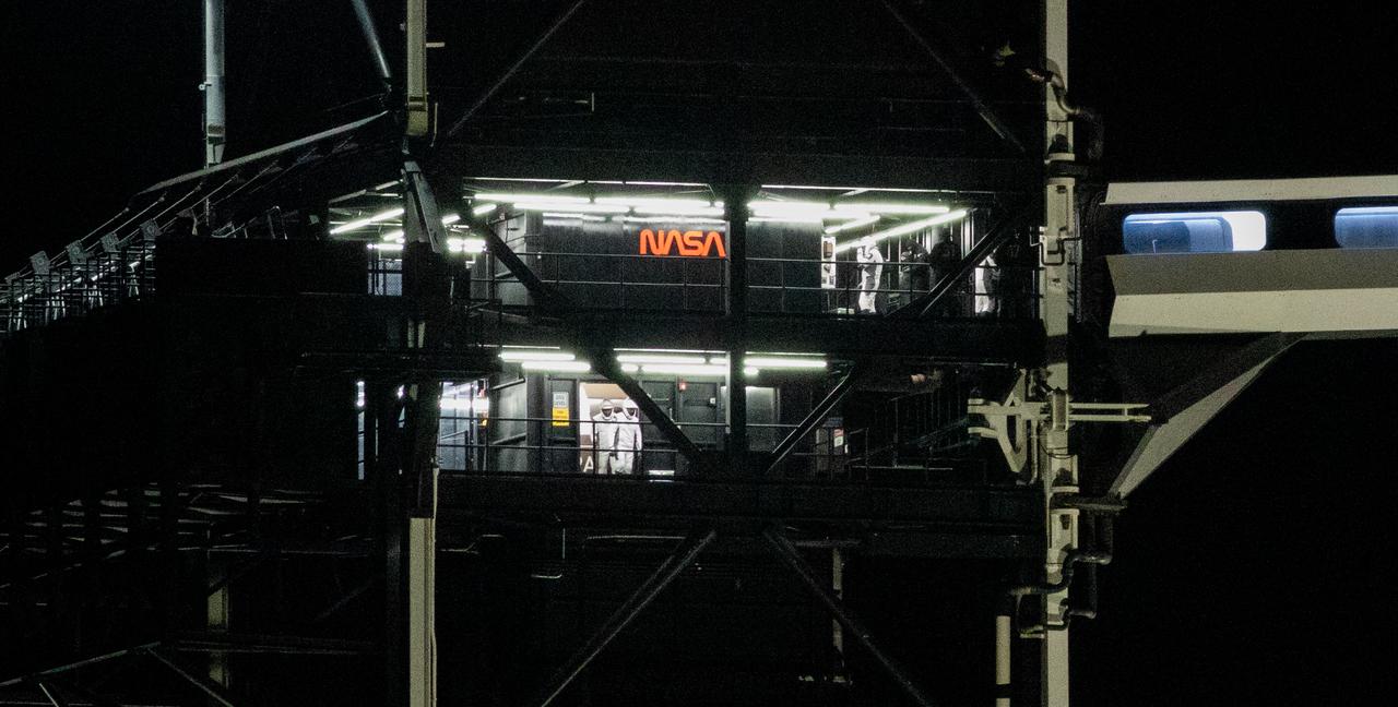 NASA astronauts Stephen Bowen and Warren "Woody" Hoburg by the crew access arm on the fixed service structure of Launch Complex 39A as fellow crewmates Roscosmos cosmonaut Andrey Fedyaev and UAE (United Arab Emirates) astronaut Sultan Alneyadi exit the elevator the floor below before boarding SpaceX’s Dragon spacecraft atop the company’s Falcon 9 rocket before the launch of NASA’s SpaceX Crew-6 mission to the International Space Station, Wednesday, March 1, 2023, at NASA’s Kennedy Space Center in Florida. NASA’s SpaceX Crew-6 mission is the sixth crew rotation mission of the SpaceX Dragon spacecraft and Falcon 9 rocket to the International Space Station as part of the agency’s Commercial Crew Program. Bowen, Hoburg, Roscosmos cosmonaut Andrey Fedyaev, and UAE (United Arab Emirates) astronaut Sultan Alneyadi launched at 12:34 a.m. EST from Launch Complex 39A at the Kennedy Space Center to begin a six month mission aboard the orbital outpost. Photo Credit: (NASA/Joel Kowsky)