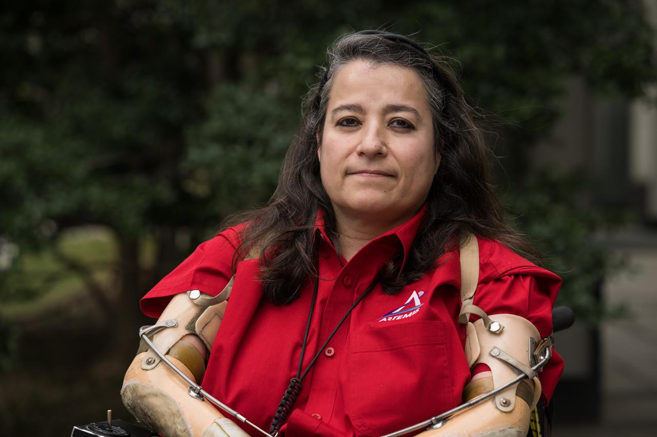 "There are a lot of things I can do that other people who are 'able-bodied' can't. For example, I was at Costco, and they hadn't opened the doors yet, so we were all waiting outside (Costco customers, gotta love them. Every day is Black Friday). Anyway, I'm sitting there at the door waiting to go in. The security guard was trying to separate these two flatbed carts, and I asked him, and I was sincere when I said this, I go, 'Do you want help?' [He says] ‘Oh, hahaha no, no.’ And that really makes me mad.   “Nine out of ten times when I offer my help, that's the response. Number one, people think I'm joking. Number two, how could I ever be helpful? Somebody in my position, 'my position,' right?   "So, he gave up, and I took my chair and quickly hit the carts at the right spot. Because of my chair being heavy, I was able to separate them. Did that teach him a lesson not to do that ever again? Probably not. But the truth is, I was able to do that, and he wasn't. And he would never guess I could do something he can't do.  “I wish people would look at us and say, wow, I wonder what she can do that is really cool, because that's how I look at my community. I don't look at the fact that they can't walk. I look and wonder what they could do. I would like to see [more of] that, so I'll keep offering my help. People need to realize not to make assumptions. Be open and curious about the abilities of everybody.   “They say if you live long enough, there's a good chance you'll join this community. And just remember, if that were to happen, don't give up because with the right resources, you can have a great life. I know people who have become disabled who tell me their life didn't begin until they became part of the community because it's given them this whole new perspective and value to people, to the human spirit.   “And that's what I like to impart to everybody; don't feel sorry for me because, with the right help, it's great."   NASA Headquarters External Informa