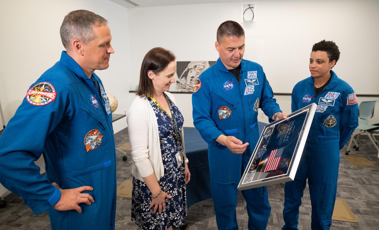 NASA astronaut Kjell Lindgren, center, along with fellow astronauts Robert Hines, left, and Jessica Watkins, right, present Smithsonian National Air and Space Museum curator Jennifer Levasseur with a montage from their mission to the International Space Station, Tuesday, March 28, 2023 at the Smithsonian’s National Air and Space Museum in Washington. Lindgren, Hines, and Watkins spent 170 days in space as part of Expeditions 67 and 68 aboard the International Space Station. Photo Credit: (NASA/Joel Kowsky)