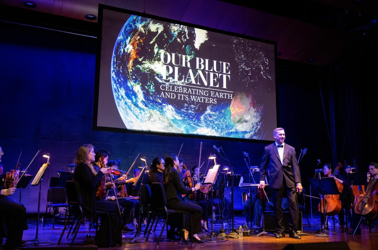 Emil de Cou and the Catholic University Orchestra are seen Wednesday, April 5, 2023, during the “Our Blue Planet” concert at the John F. Kennedy Center for the Performing Arts in Washington. Jeannie Schulz, widow of Peanuts gang creator Charles M. Schulz, was awarded a NASA Exceptional Achievement Medal by NASA Administrator Bill Nelson at the concert. Snoopy rode along as the zero gravity indicator on NASA’s Artemis I mission as part of a partnership with the agency and continues to help NASA inspire kids of all ages to follow along with Artemis missions.  Photo Credit: (NASA/Joel Kowsky)