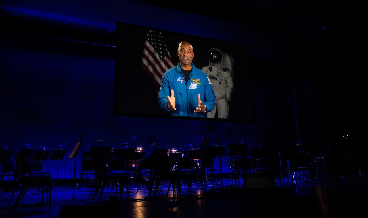 NASA astronaut Victor Glover is seen on screen in a video, Wednesday, April 5, 2023, during the “Our Blue Planet” concert at the John F. Kennedy Center for the Performing Arts in Washington. Jeannie Schulz, widow of Peanuts gang creator Charles M. Schulz, was awarded a NASA Exceptional Achievement Medal by NASA Administrator Bill Nelson at the concert. Snoopy rode along as the zero gravity indicator on NASA’s Artemis I mission as part of a partnership with the agency and continues to help NASA inspire kids of all ages to follow along with Artemis missions. Photo Credit: (NASA/Joel Kowsky)