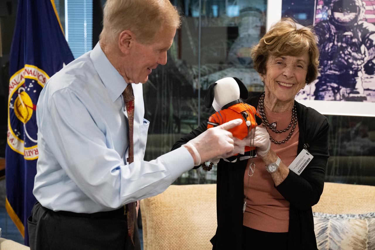 NASA Administrator Bill Nelson, left, is seen with Jeannie Schulz, widow of Peanuts gang creator Charles M. Schulz, right, holding the Artemis I Snoopy zero gravity indicator, Wednesday, April 5, 2023, during a visit to the Mary W. Jackson NASA Headquarters building in Washington. Schulz awarded a NASA Exceptional Achievement Medal by Administrator Nelson at an “Our Blue Planet” concert at the John F. Kennedy Center for the Performing Arts. Snoopy rode along as the zero gravity indicator on NASA’s Artemis I mission as part of a partnership with the agency and continues to help NASA inspire kids of all ages to follow along with Artemis missions. As part of the visit, Schulz showed the flown Artemis I Snoopy zero gravity indicator before it goes to its final home for display at the Schulz Museum in Santa Rosa, California.  Photo Credit: (NASA/Joel Kowsky)