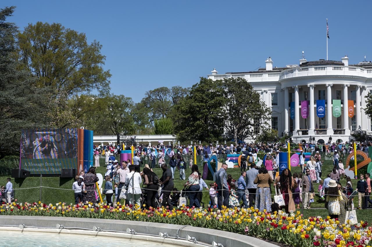 NASA astronaut Warren "Woody" Hoburg is seen on screen, left, during a downlink from the International Space Station (ISS) during the White House Easter Egg Roll, Monday, April 10, 2023, on the South Lawn of the White House in Washington. Photo Credit: (NASA/Keegan Barber)