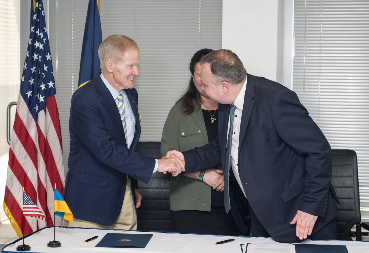 NASA Administrator Bill Nelson, left, shakes hands with Deputy Chairman of the State Space Agency of Ukraine, Volodymyr Mikheiev, while Ambassador of Ukraine, Her Excellency Oksana Markarova looks on, after a joint statement on civil space cooperation between NASA and the State Space Agency of Ukraine was signed, Friday April 21, 2023 at the Mary W. Jackson NASA Headquarters building in Washington DC. Photo Credit: (NASA/Aubrey Gemignani)
