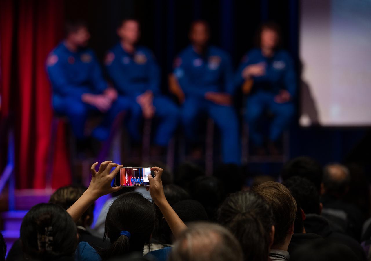 A member of the audience takes a video as CSA (Canadian Space Agency) astronaut Jeremy Hansen, and NASA astronauts Reid Wiseman, Victor Glover, and Christina Hammock Koch, answer questions during an employee engagement event Friday, May 19, 2023, at NASA’s Goddard Space Flight Center in Greenbelt, Md. Wiseman, Glover, Hammock Koch, and Hansen, who will fly around the Moon on NASA’s Artemis II flight test, visited Washington to discuss their upcoming mission with members of Congress and others. Photo Credit: (NASA/Joel Kowsky)