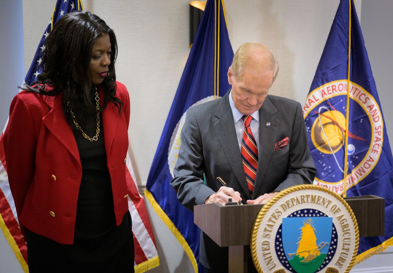 NASA Administrator Bill Nelson signs a memorandum of understanding between NASA and USDA, as Undersecretary of Agriculture for research, education and economics, Chavonda Jacobs-Young, looks on, Wednesday, June 21, 2023, at the USDA’s Jamie L. Whitten Building in Washington. The agreement strengthens the collaboration between the two agencies, including efforts to improve agricultural and Earth science research, technology, and agricultural management, as well as the application of science data and models to agricultural decision making. Photo Credit: (NASA/Bill Ingalls)