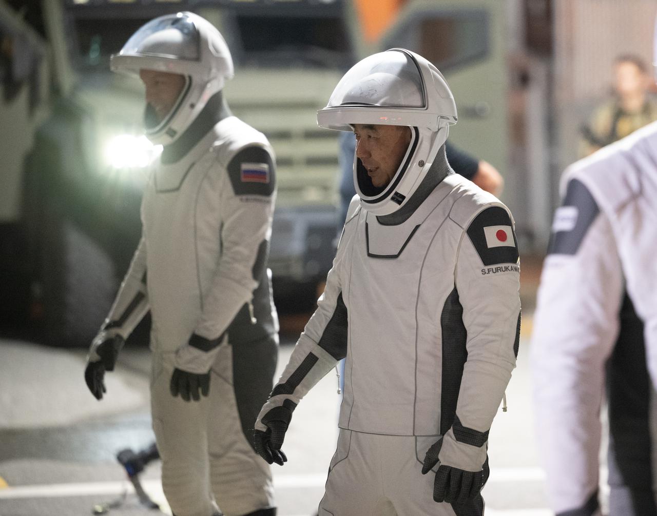 (JAXA) astronaut Satoshi Furukawa and Roscosmos cosmonaut Konstantin Borisov, wearing SpaceX spacesuits, are seen as they prepare to depart the Neil  A. Armstrong Operations and Checkout Building along with fellow crewmates NASA astronaut Jasmin Moghbeli and ESA (European Space Agency) astronaut Andreas Mogensen, for Launch Complex 39A during a dress rehearsal prior to the Crew-7 mission launch, Tuesday, Aug. 22, 2023, at NASA’s Kennedy Space Center in Florida. NASA’s SpaceX Crew-7 mission is the seventh crew rotation mission of the SpaceX Dragon spacecraft and Falcon 9 rocket to the International Space Station as part of the agency’s Commercial Crew Program. Moghbeli, Mogensen, Furukawa, and Borisov are scheduled to launch at 3:49 a.m. EDT on Friday, August 25, from Launch Complex 39A at the Kennedy Space Center. Photo Credit: (NASA/Joel Kowsky)