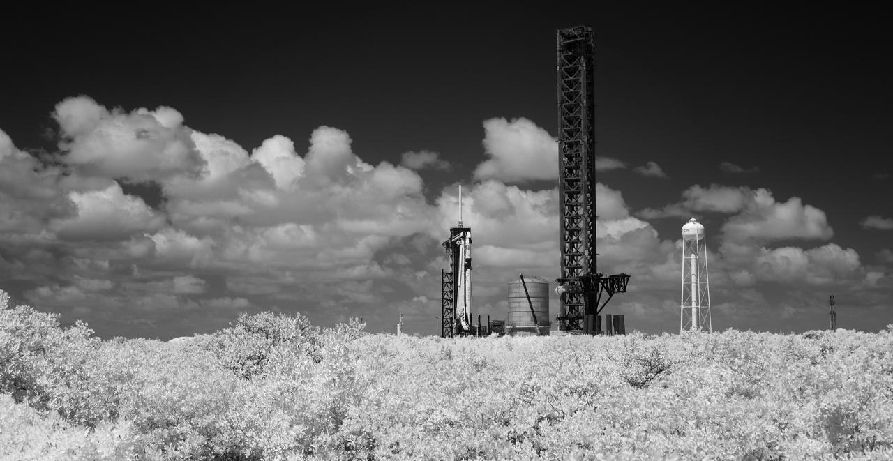 In this black and white infrared image, a SpaceX Falcon 9 rocket with the company's Dragon spacecraft on top is seen on the launch pad at Launch Complex 39A as preparations continue for the Crew-7 mission, Friday, Aug. 25, 2023, at NASA’s Kennedy Space Center in Florida. NASA’s SpaceX Crew-7 mission is the seventh crew rotation mission of the SpaceX Crew Dragon spacecraft and Falcon 9 rocket to the International Space Station as part of the agency’s Commercial Crew Program. NASA astronaut Jasmin Moghbeli, ESA (European Space Agency) astronaut Andreas Mogensen, Japan Aerospace Exploration Agency (JAXA) astronaut Satoshi Furukawa, and Roscosmos cosmonaut Konstantin Borisov are scheduled to launch at 3:27 a.m. EDT on Saturday, August 26, from Launch Complex 39A at the Kennedy Space Center. Photo Credit: (NASA/Joel Kowsky)