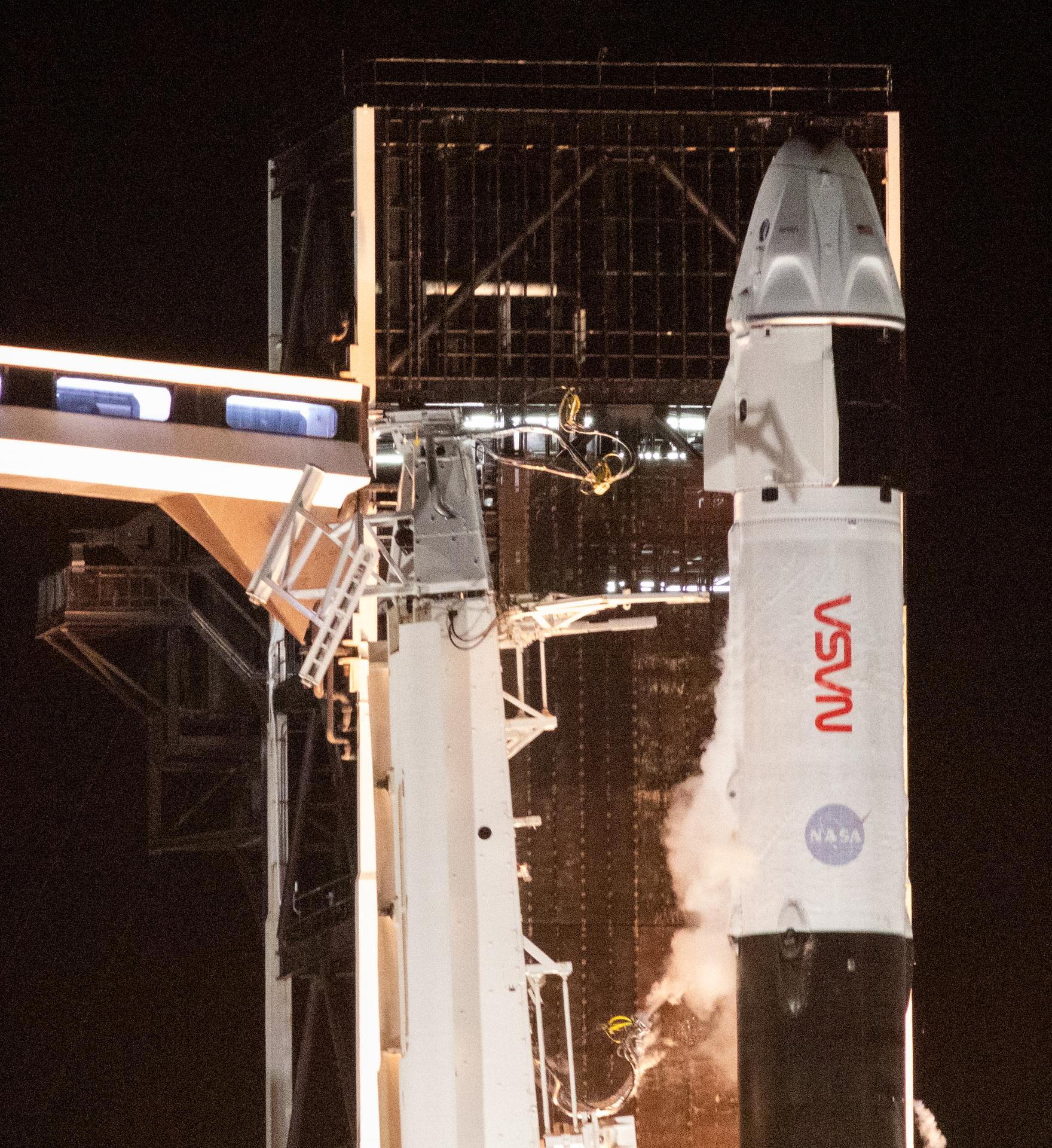 An up-close view of the crew access arm and SpaceX Dragon spacecraft atop the company's Falcon 9 rocket at the launch pad.