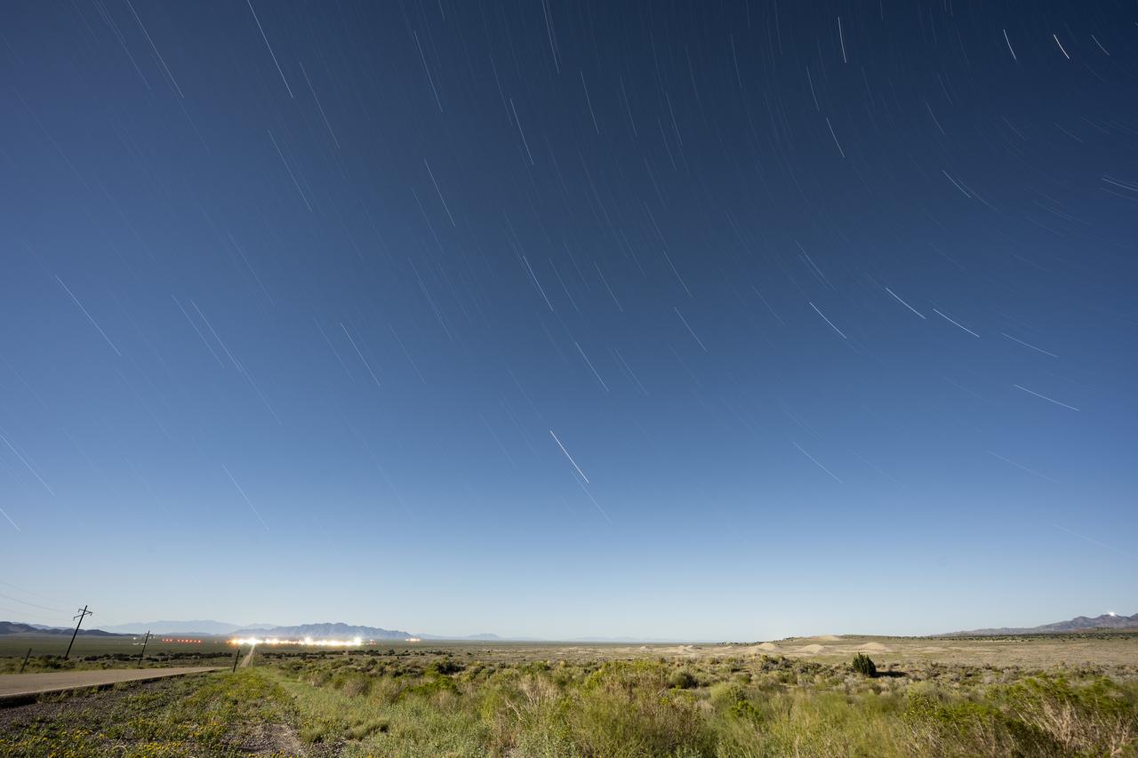 In this 30 minute exposure, star trails are seen above Michael Army Air Field and Dugway Proving Ground, Sunday, Aug. 27, 2023, near Dugway, Utah. Recovery teams met in August for rehearsals in preparation for the retrieval of the sample return capsule from NASA's OSIRIS-REx mission. The sample was collected from the asteroid Bennu in October 2020 by NASA’s OSIRIS-REx spacecraft and will return to Earth on September 24th, landing under parachute at the Department of Defenses Utah Test and Training Range. Photo Credit: (NASA/Keegan Barber)