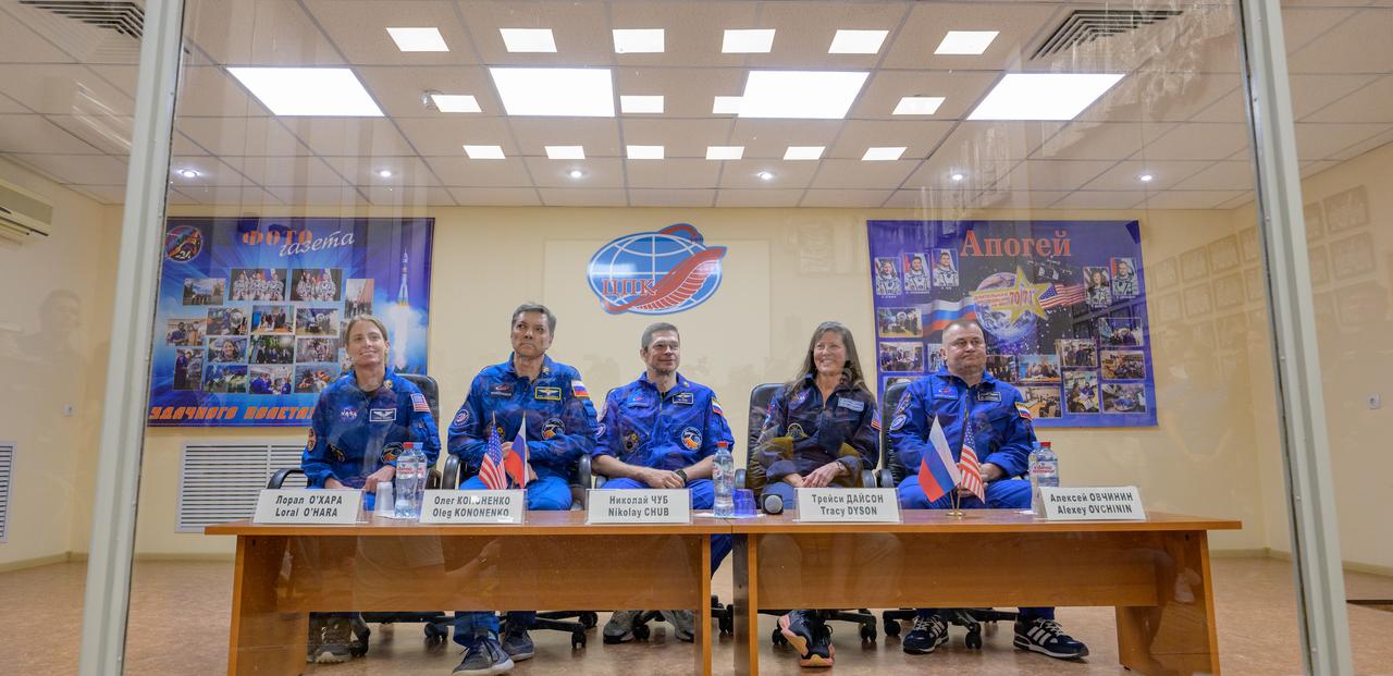 Expedition 70 prime crew NASA astronaut Loral O'Hara, left, Roscosmos cosmonauts Oleg Kononenko, and Nikolai Chub, along with backup crew members Tracy Dyson and Alexey Ovchinin, right, are seen in quarantine behind glass during a press conference, Thursday, Sept. 14, 2023 at the Cosmonaut Hotel in Baikonur, Kazakhstan. O'Hara, Kononenko, Chub are scheduled to launch aboard their Soyuz MS-24 spacecraft on Sept. 15. Photo Credit: (NASA/Bill Ingalls)