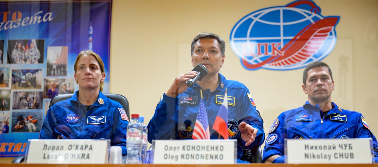 Expedition 70 NASA astronaut Loral O'Hara, left, Roscosmos cosmonauts Oleg Kononenko, and Nikolai Chub, right, are seen in quarantine behind glass during a press conference, Thursday, Sept. 14, 2023 at the Cosmonaut Hotel in Baikonur, Kazakhstan. O'Hara, Kononenko, Chub are scheduled to launch aboard their Soyuz MS-24 spacecraft on Sept. 15. Photo Credit: (NASA/Bill Ingalls)