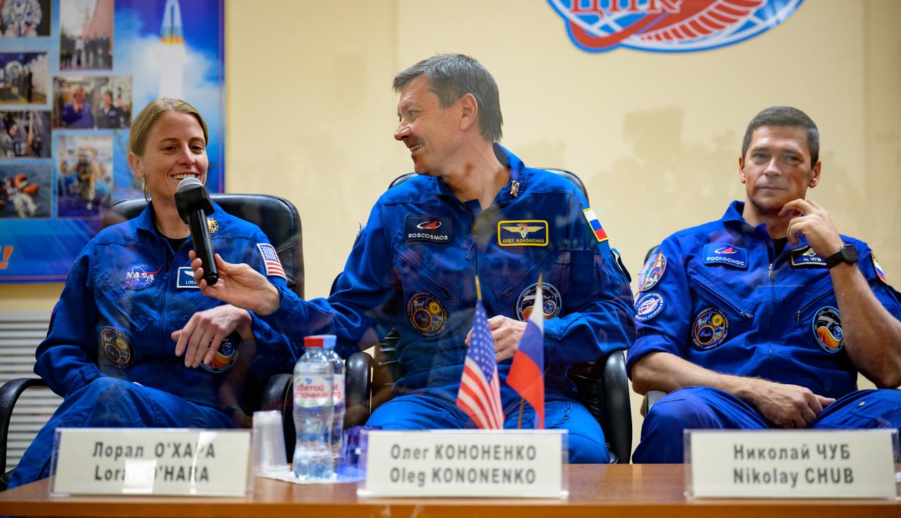 Expedition 70 NASA astronaut Loral O'Hara, left, Roscosmos cosmonauts Oleg Kononenko, and Nikolai Chub, right, are seen in quarantine behind glass during a press conference, Thursday, Sept. 14, 2023 at the Cosmonaut Hotel in Baikonur, Kazakhstan. O'Hara, Kononenko, Chub are scheduled to launch aboard their Soyuz MS-24 spacecraft on Sept. 15. Photo Credit: (NASA/Bill Ingalls)