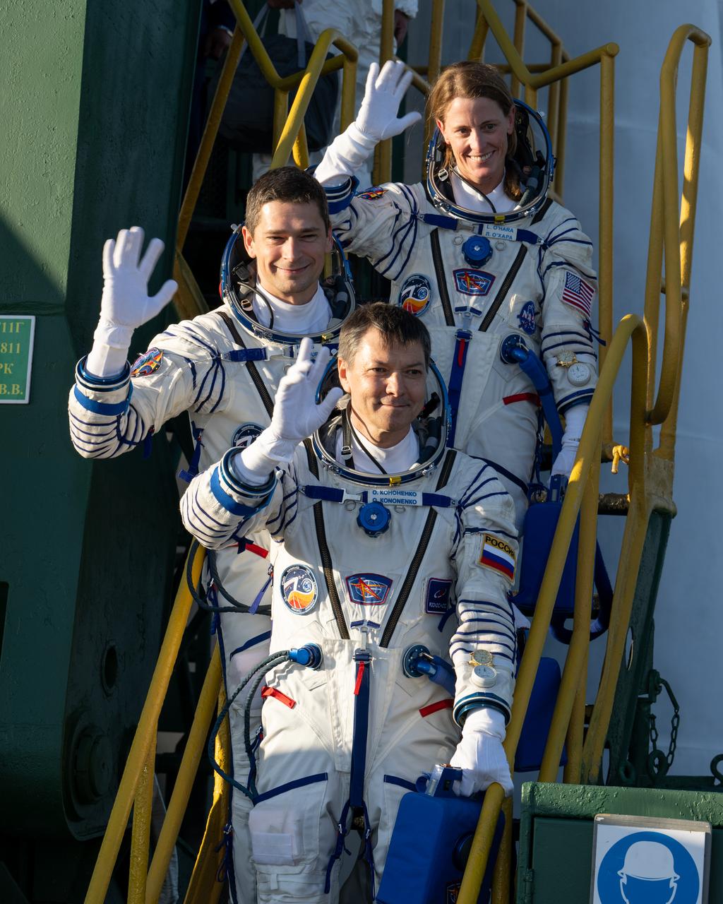 Expedition 70 crew members NASA astronaut Loral O’Hara, top, and Roscosmos cosmonauts Nikolai Chub, middle, and Oleg Kononenko wave farewell prior to boarding the Soyuz MS-24 spacecraft for launch, Friday, Sept. 15, 2023 at the Baikonur Cosmodrome in Kazakhstan. Launch of the Soyuz rocket will send the trio on a mission to the International Space Station. Photo Credit: (NASA/Bill Ingalls)