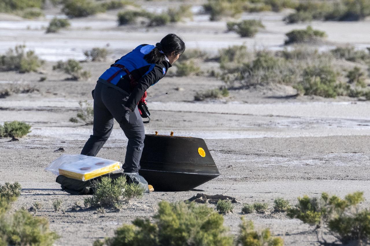 Lockheed Martin System Safety Engineer Victoria Thiem performs preliminary checks on the sample return capsule from NASA’s OSIRIS-REx mission, Sunday, Sept. 24, 2023, shortly after the capsule landed at the Department of Defense's Utah Test and Training Range. The sample was collected from the asteroid Bennu in October 2020 by NASA’s OSIRIS-REx spacecraft. Photo Credit: (NASA/Keegan Barber)