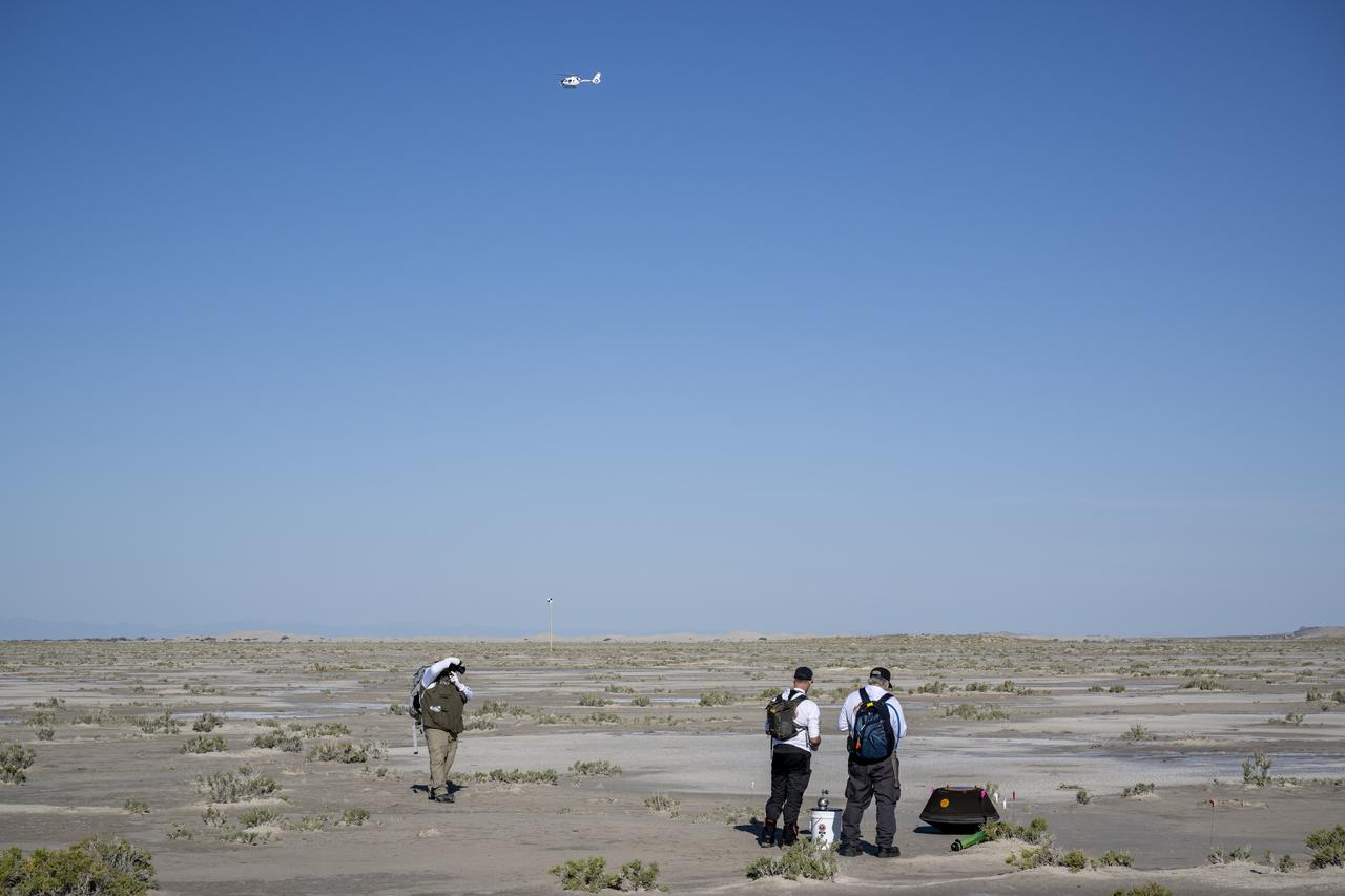 From left to right, NASA Astromaterials Curator Francis McCubbin, University of Arizona OSIRIS-REx Principal Investigator Dante Lauretta, and NASA Sample Return Capsule Science Lead Scott Sandford collect science data, Sunday, Sept. 24, 2023, shortly after the sample return capsule from NASA’s OSIRIS-REx mission landed at the Department of Defense's Utah Test and Training Range. The sample was collected from the asteroid Bennu in October 2020 by NASA’s OSIRIS-REx spacecraft. Photo Credit: (NASA/Keegan Barber)