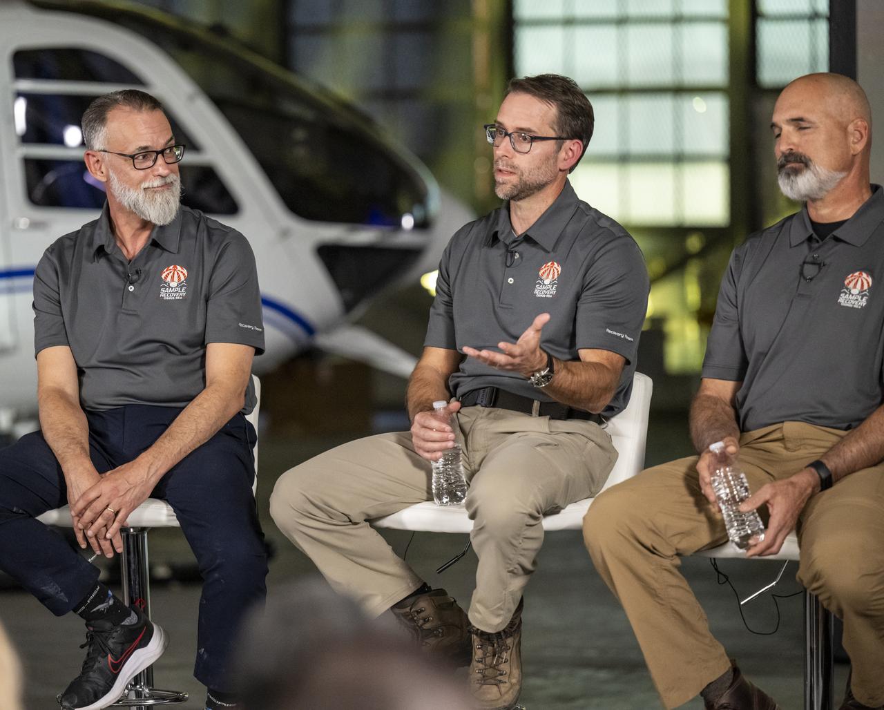 NASA OSIRIS-REx Deputy Project Manager Mike Moreau, center, answers questions from reporters during an OSIRIS-REx sample return press conference, Sunday, Sept. 24, 2023, shortly after the capsule landed at the Department of Defense's Utah Test and Training Range. The sample was collected from the asteroid Bennu in October 2020 by NASA’s OSIRIS-REx spacecraft. Photo Credit: (NASA/Keegan Barber)