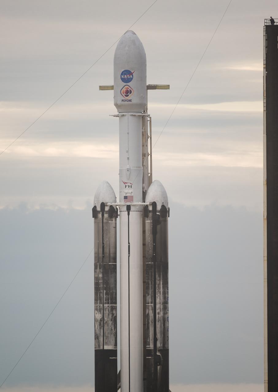 A SpaceX Falcon Heavy rocket with the Psyche spacecraft onboard is seen at Launch Complex 39A as preparations continue for the Psyche mission, Wednesday, Oct. 11, 2023, at NASA’s Kennedy Space Center in Florida. NASA’s Psyche spacecraft will travel to a metal-rich asteroid by the same name orbiting the Sun between Mars and Jupiter to study it’s composition. The spacecraft also carries the agency's Deep Space Optical Communications technology demonstration, which will test laser communications beyond the Moon. Photo Credit: (NASA/Aubrey Gemignani)