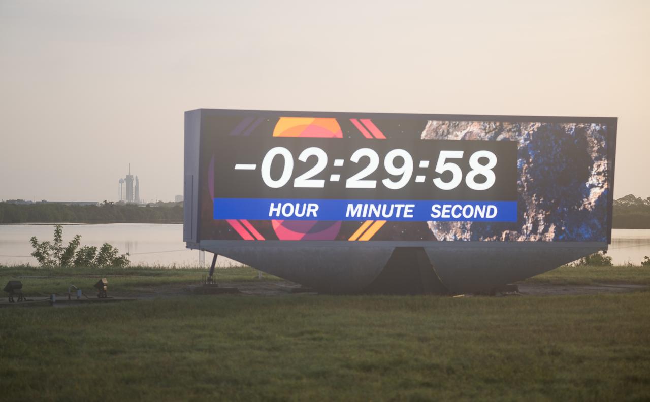 A SpaceX Falcon Heavy rocket with the Psyche spacecraft onboard is seen at Launch Complex 39A next to the countdown clock, as preparations continue for the Psyche mission, Friday, Oct. 13, 2023, at NASA’s Kennedy Space Center in Florida. NASA’s Psyche spacecraft will travel to a metal-rich asteroid by the same name orbiting the Sun between Mars and Jupiter to study it’s composition. The spacecraft also carries the agency's Deep Space Optical Communications technology demonstration, which will test laser communications beyond the Moon. Photo Credit: (NASA/Aubrey Gemignani)
