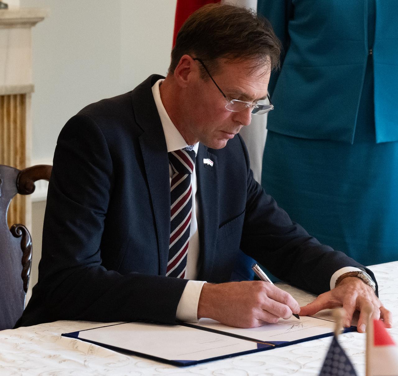 Harm van de Wetering, director of the Netherlands Space Office, center, signs the Artemis Accords, Wednesday, Nov. 1, 2023, at the Dutch Ambassador’s Residence in Washington. Netherlands is the 31st country to sign the Artemis Accords, which establish a practical set of principles to guide space exploration cooperation among nations participating in NASA’s Artemis program.  Photo Credit: (NASA/Joel Kowsky)