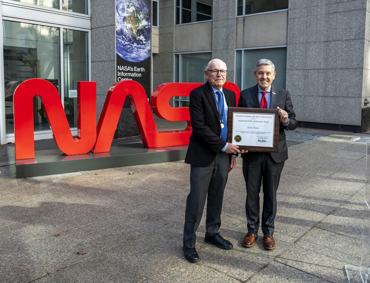 NASA Associate Administrator Bob Cabana, right, poses for a photo with Richard Danne after awarding him the Exceptional Public Achievement Medal for his outstanding achievement in creating the NASA worm logotype, Monday, Nov. 6, 2023, at the Mary W. Jackson NASA Headquarters building in Washington. Photo Credit: (NASA/Keegan Barber)