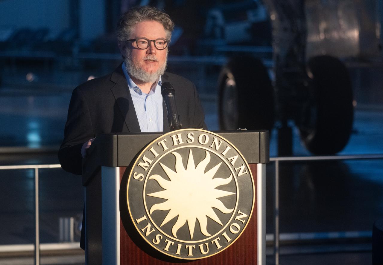 Matt Shindell, space history curator at the National Air and Space Museum speaks at an event marking NASA’s donation of the aerial prototype of the Ingenuity Mars Helicopter, Friday, Dec. 15, 2023, at the Smithsonian National Air and Space Museum’s Steve F. Udvar-Hazy Center in Chantilly, Va. The aerial prototype of the Ingenuity Mars Helicopter, which was the first to demonstrate it was possible to fly in a simulated Mars environment at NASA’s Jet Propulsion Laboratory (JPL), was donated to the museum on Friday.  Photo Credit: (NASA/Joel Kowsky)The aerial prototype of the Ingenuity Mars Helicopter is seen at the Smithsonian National Air and Space Museum’s Steve F. Udvar-Hazy Center, Friday, Dec. 15, 2023, in Chantilly, Va. The prototype, which demonstrated it was possible to fly in a simulated Mars environment at NASA’s Jet Propulsion Laboratory (JPL), was donated  Photo Credit: (NASA/Joel Kowsky)