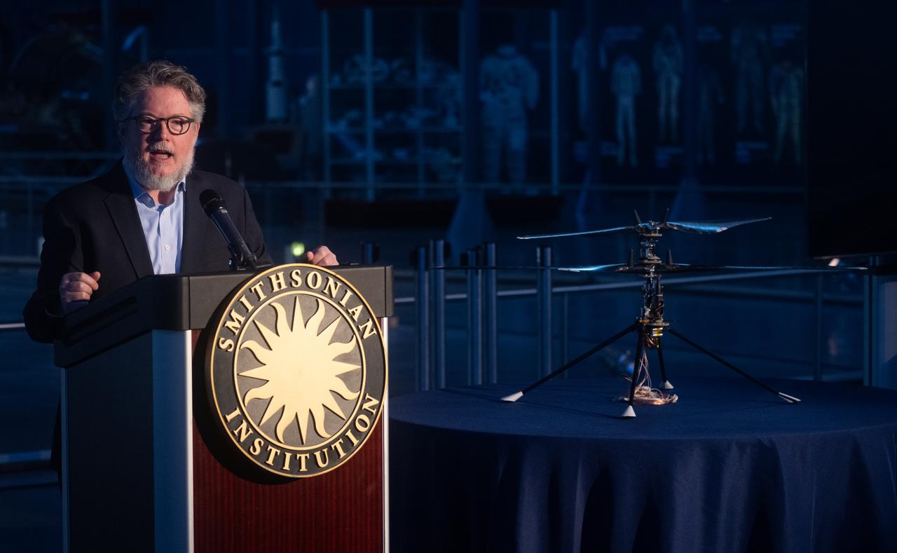 Matt Shindell, space history curator at the National Air and Space Museum speaks at an event marking NASA’s donation of the aerial prototype of the Ingenuity Mars Helicopter, Friday, Dec. 15, 2023, at the Smithsonian National Air and Space Museum’s Steve F. Udvar-Hazy Center in Chantilly, Va. The aerial prototype of the Ingenuity Mars Helicopter, which was the first to demonstrate it was possible to fly in a simulated Mars environment at NASA’s Jet Propulsion Laboratory (JPL), was donated to the museum on Friday.  Photo Credit: (NASA/Joel Kowsky)