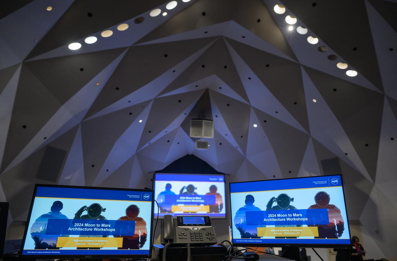 The opening presentation slide for the Moon to Mars Architecture Workshop is seen on monitors, Tuesday, Feb. 20, 2024, at the National Academy of Sciences in Washington. NASA held the workshop to engage the broader space community and collect feedback from U.S. industry and academia and international partners to inform NASA's Moon to Mars Architecture, the agency's roadmap for human exploration of the Moon and Mars. Photo Credit: (NASA/Bill Ingalls)