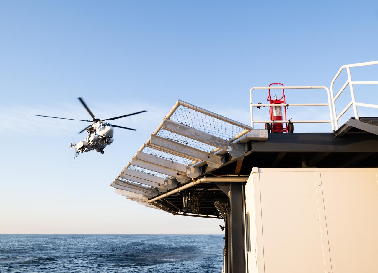 The helicopter that will carry cargo and support personnel back to shore is seen as it approaches the SpaceX recovery ship MEGAN in the Gulf of Mexico off the coast of Pensacola, Florida, Tuesday, March 12, 2024. Moghbeli, Mogensen, Furukawa, and Borisov are returning after nearly six-months in space as part of Expedition 70 aboard the International Space Station. Photo Credit: (NASA/Joel Kowsky)