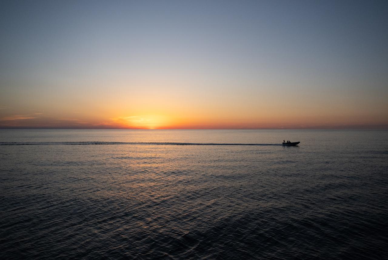 A fast boat is seen at sunrise after the landing of SpaceX Dragon Endurance spacecraft a few hours earlier with NASA astronaut Jasmin Moghbeli, ESA (European Space Agency) astronaut Andreas Mogensen, Japan Aerospace Exploration Agency (JAXA) astronaut Satoshi Furukawa, and Roscosmos cosmonaut Konstantin Borisov aboard in the Gulf of Mexico off the coast of Pensacola, Florida, Tuesday, March 12, 2024. Moghbeli, Mogensen, Furukawa, and Borisov are returning after nearly six-months in space as part of Expedition 70 aboard the International Space Station. Photo Credit: (NASA/Joel Kowsky)