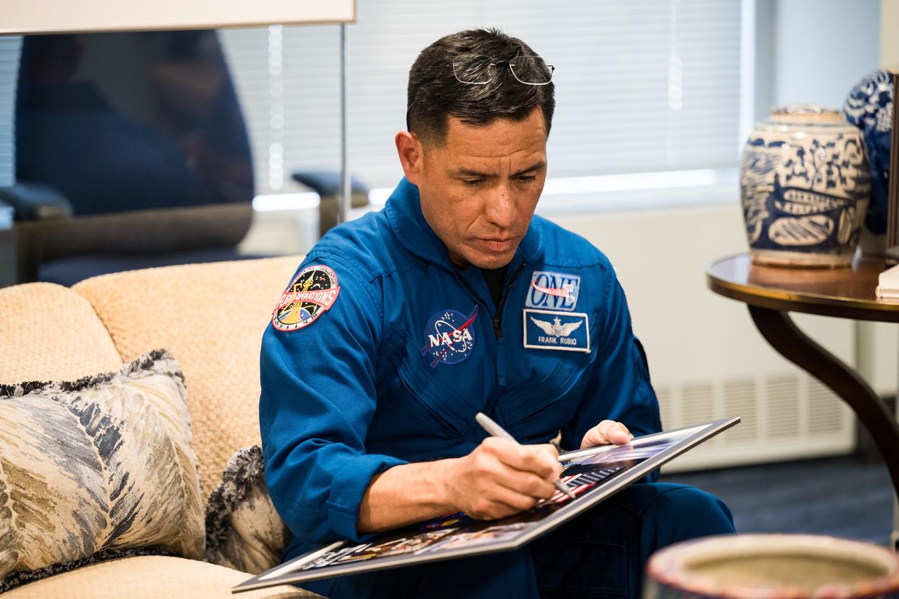 Expedition 69 NASA astronaut Frank Rubio signs a montage as he and fellow crewmates NASA astronauts Warren Hoburg and Stephen Bowen, and UAE (United Arab Emirates) astronaut Sultan Alneyadi meet with NASA Administrator Bill Nelson and Deputy Administrator Pam Melroy, Tuesday, March 19, 2024 at the Mary W. Jackson NASA Headquarters building in Washington. Bowen, Hoburg, and Alneyadi spent 186 days aboard the International Space Station as part of Expedition 69; while Rubio set a new record for the longest single spaceflight by a U.S. astronaut, spending 371 days in orbit on an extended mission spanning Expeditions 68 and 69. Photo Credit: (NASA/Aubrey Gemignani)