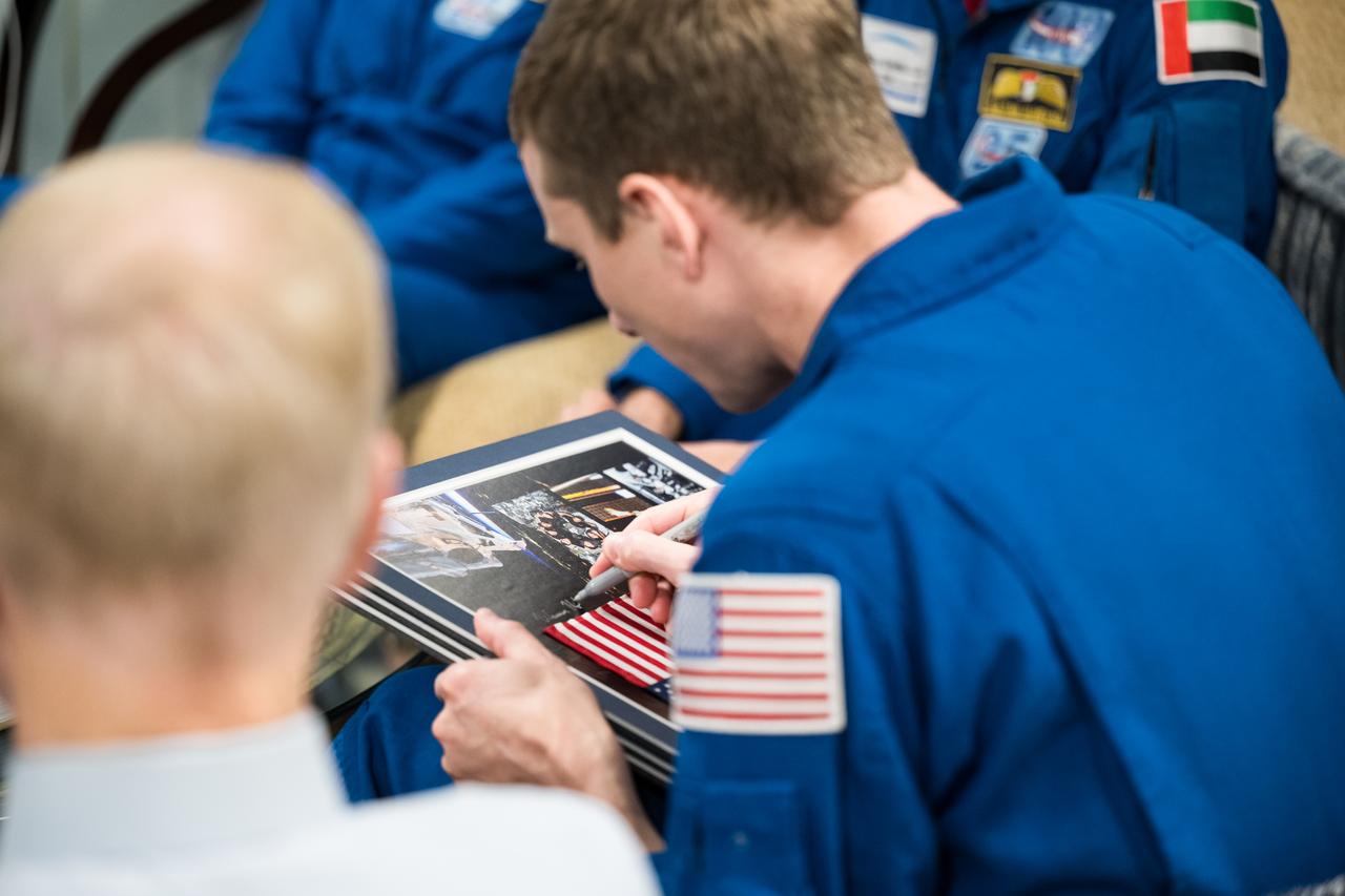 Expedition 69 NASA astronaut Warren Hoburg signs a montage as he and fellow crewmates NASA astronauts Stephen Bowen and Frank Rubio, and UAE (United Arab Emirates) astronaut Sultan Alneyadi meet with NASA Administrator Bill Nelson and Deputy Administrator Pam Melroy, Tuesday, March 19, 2024 at the Mary W. Jackson NASA Headquarters building in Washington. Bowen, Hoburg, and Alneyadi spent 186 days aboard the International Space Station as part of Expedition 69; while Rubio set a new record for the longest single spaceflight by a U.S. astronaut, spending 371 days in orbit on an extended mission spanning Expeditions 68 and 69. Photo Credit: (NASA/Aubrey Gemignani)