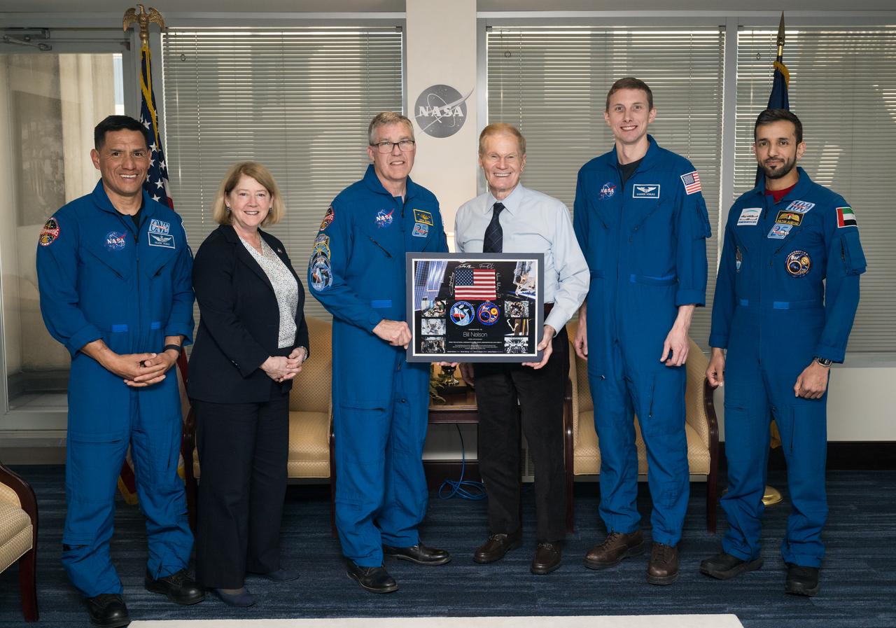 From left to right, Expedition 69 NASA astronaut Frank Rubio, NASA Deputy Administrator Pam Melroy, NASA astronaut Stephen Bowen, NASA Administrator Bill Nelson, NASA astronaut Warren Hoburg, and UAE (United Arab Emirates) astronaut Sultan Alneyadi, pose for a photo with a montage from their mission, Tuesday, March 19, 2024 at the Mary W. Jackson NASA Headquarters building in Washington. Bowen, Hoburg, and Alneyadi spent 186 days aboard the International Space Station as part of Expedition 69; while Rubio set a new record for the longest single spaceflight by a U.S. astronaut, spending 371 days in orbit on an extended mission spanning Expeditions 68 and 69. Photo Credit: (NASA/Aubrey Gemignani)