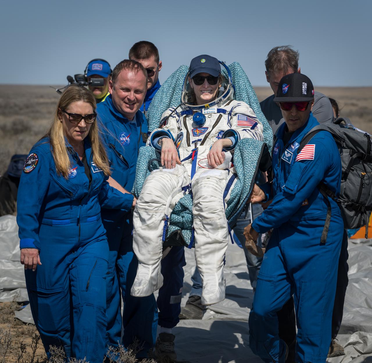 Expedition 70 NASA astronaut Loral O'Hara is carried to a medical tent by NASA ISS Program Manager Dana Weigel, left, NASA Interpreter Ilya Shlepakov, and NASA Chief of the Astronaut Office Joe Acaba, right, shortly after she, Roscosmos cosmonaut Oleg Novitskiy, and Belarus spaceflight participant Marina Vasilevskaya, landed in their Soyuz MS-24 spacecraft near the town of Zhezkazgan, Kazakhstan on Saturday, April 6, 2024. O’Hara is returning to Earth after logging 204 days in space as a member of Expeditions 69-70 aboard the International Space Station and Novitskiy and Vasilevskaya return after having spent the last 14 days in space. Photo Credit (NASA/Bill Ingalls)