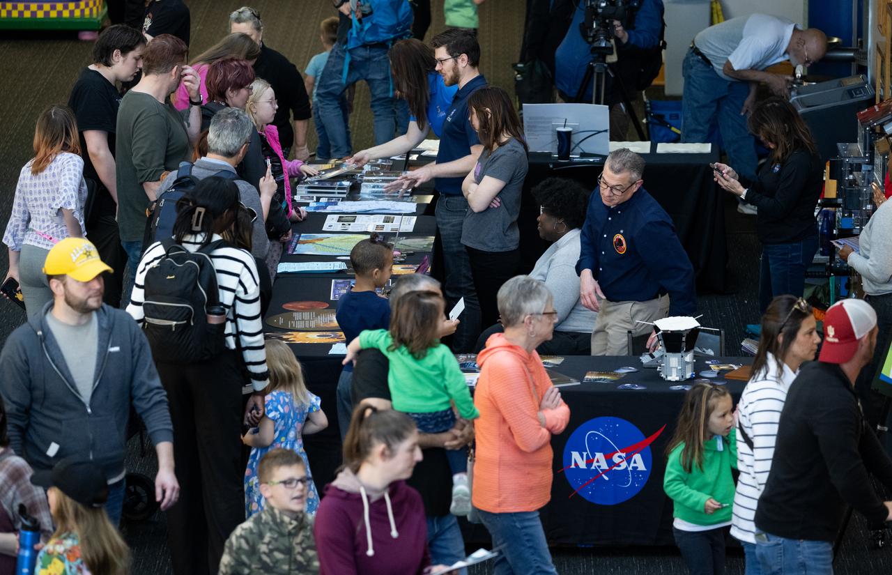 Visitors to The Children’s Museum of Indianapolis learn about the upcoming total solar eclipse from NASA staff, Saturday, April 6, 2024, in Indianapolis, Ind. On Monday, April 8, a total solar eclipse will sweep across a narrow portion of the North American continent from Mexico’s Pacific coast to the Atlantic coast of Newfoundland, Canada, while a partial solar eclipse will be visible across the entire North American continent along with parts of Central America and Europe. Photo Credit: (NASA/Joel Kowsky)