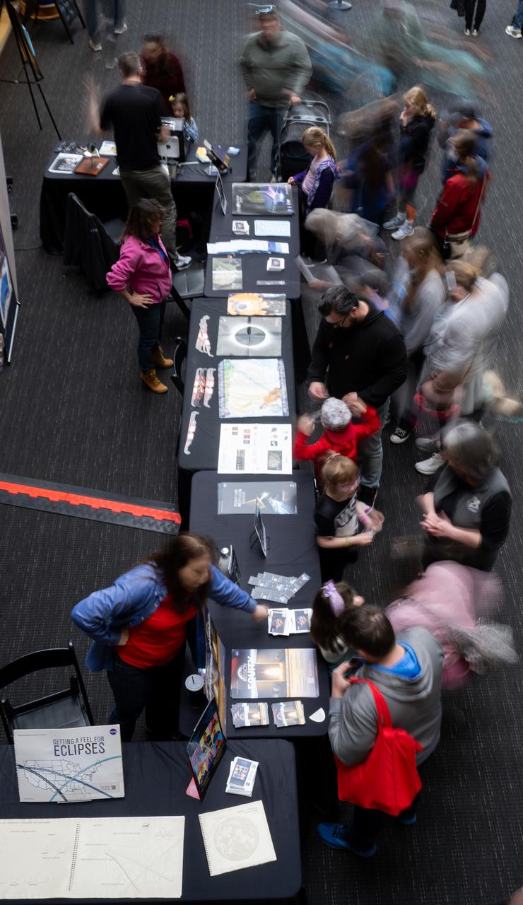 Visitors to The Children’s Museum of Indianapolis learn about the upcoming total solar eclipse from NASA staff, Sunday, April 7, 2024, in Indianapolis, Ind. On Monday, April 8, a total solar eclipse will sweep across a narrow portion of the North American continent from Mexico’s Pacific coast to the Atlantic coast of Newfoundland, Canada, while a partial solar eclipse will be visible across the entire North American continent along with parts of Central America and Europe. Photo Credit: (NASA/Joel Kowsky)