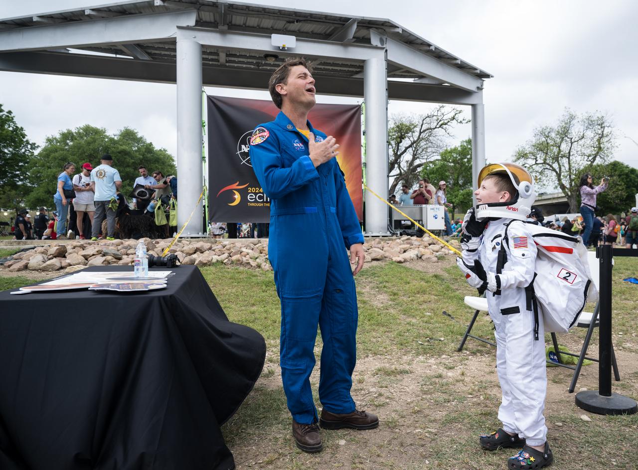 Astronaut Reid Wiseman reacts to a guest dressed as an astronaut at the Kerrville eclipse festival in Kerrville, TX on Monday, April 8, 2024. A total solar eclipse swept across a narrow portion of the North American continent from Mexico’s Pacific coast to the Atlantic coast of Newfoundland, Canada. A partial solar eclipse was visible across the entire North American continent along with parts of Central America and Europe.  Photo Credit: (NASA/Aubrey Gemignani)