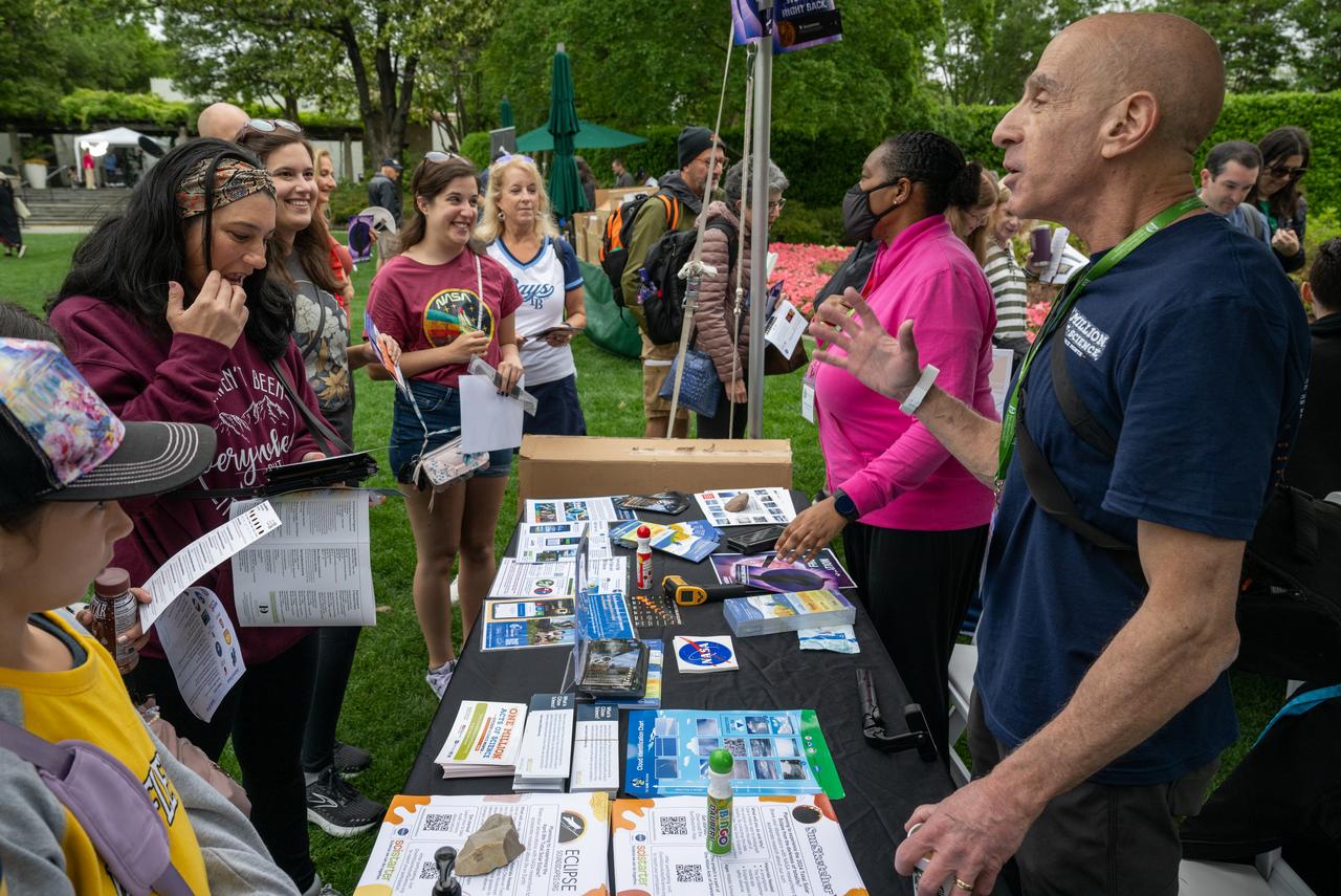 Guests learn about the total solar eclipse from NASA staff at the Dallas Arboretum, Monday, April 8, 2024, in Dallas, Texas. A total solar eclipse swept across a narrow portion of the North American continent from Mexico’s Pacific coast to the Atlantic coast of Newfoundland, Canada. A partial solar eclipse was visible across the entire North American continent along with parts of Central America and Europe. Photo Credit: (NASA/Keegan Barber) in Dallas, Texas on Monday, April 8, 2024. A total solar eclipse swept across a narrow portion of the North American continent from Mexico’s Pacific coast to the Atlantic coast of Newfoundland, Canada. A partial solar eclipse was visible across the entire North American continent along with parts of Central America and Europe. Photo Credit: (NASA/Keegan Barber)